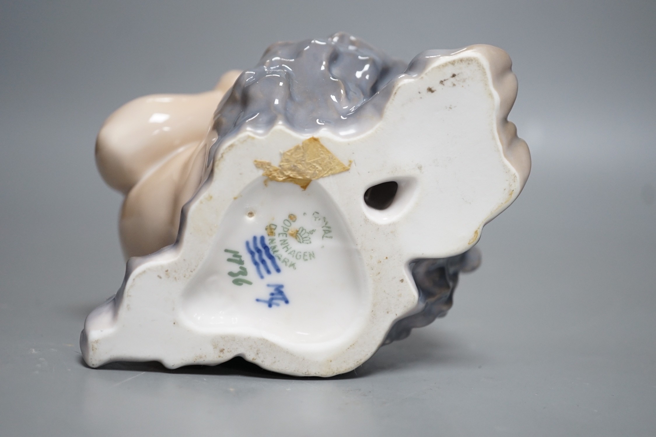 A Royal Copenhagen porcelain model of a seated faun, number 1736, 13cm tall